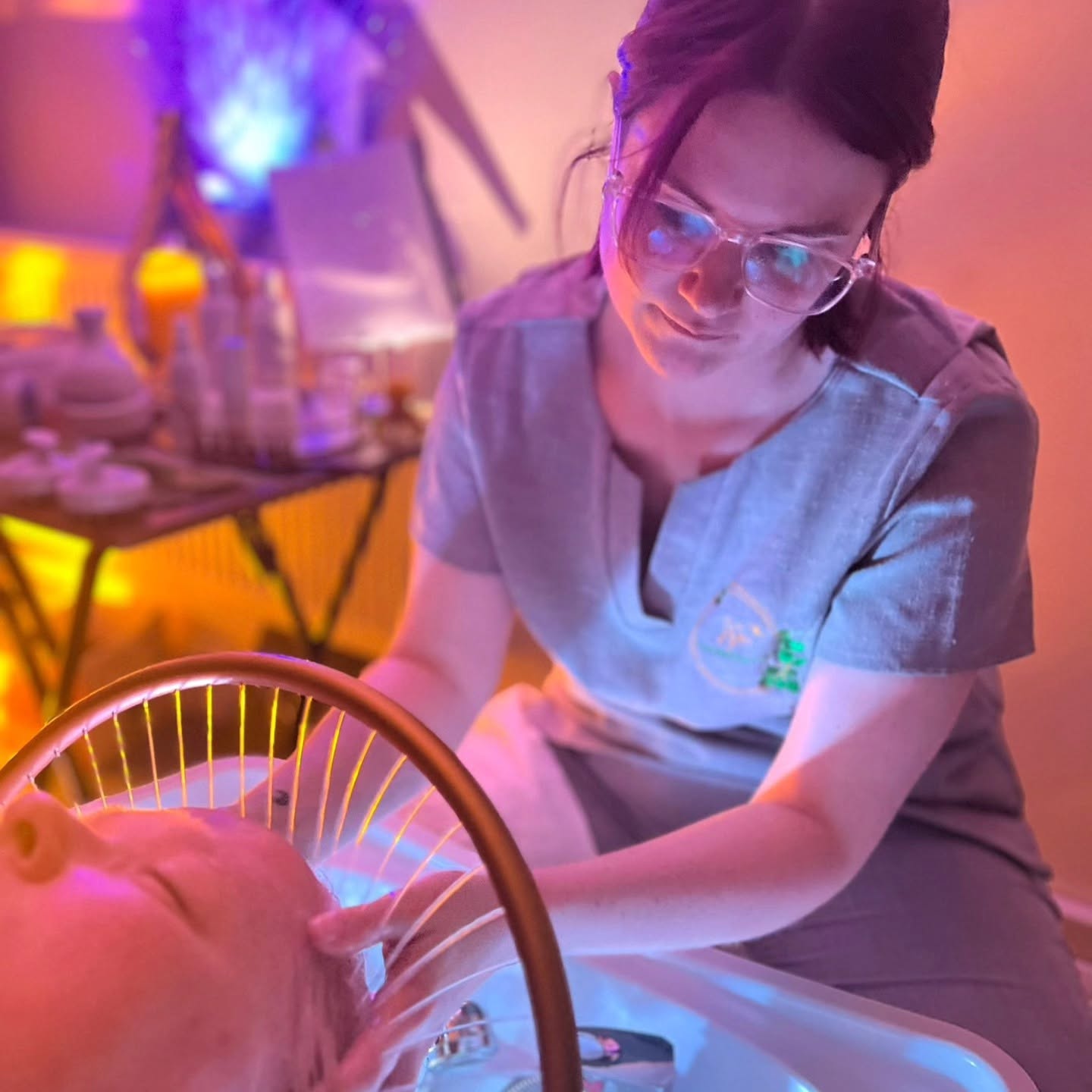 Astra from Astar Therapeutics giving a Japanese head spa treatment, with a client's head resting over the spa basin under warm, glowing lighting