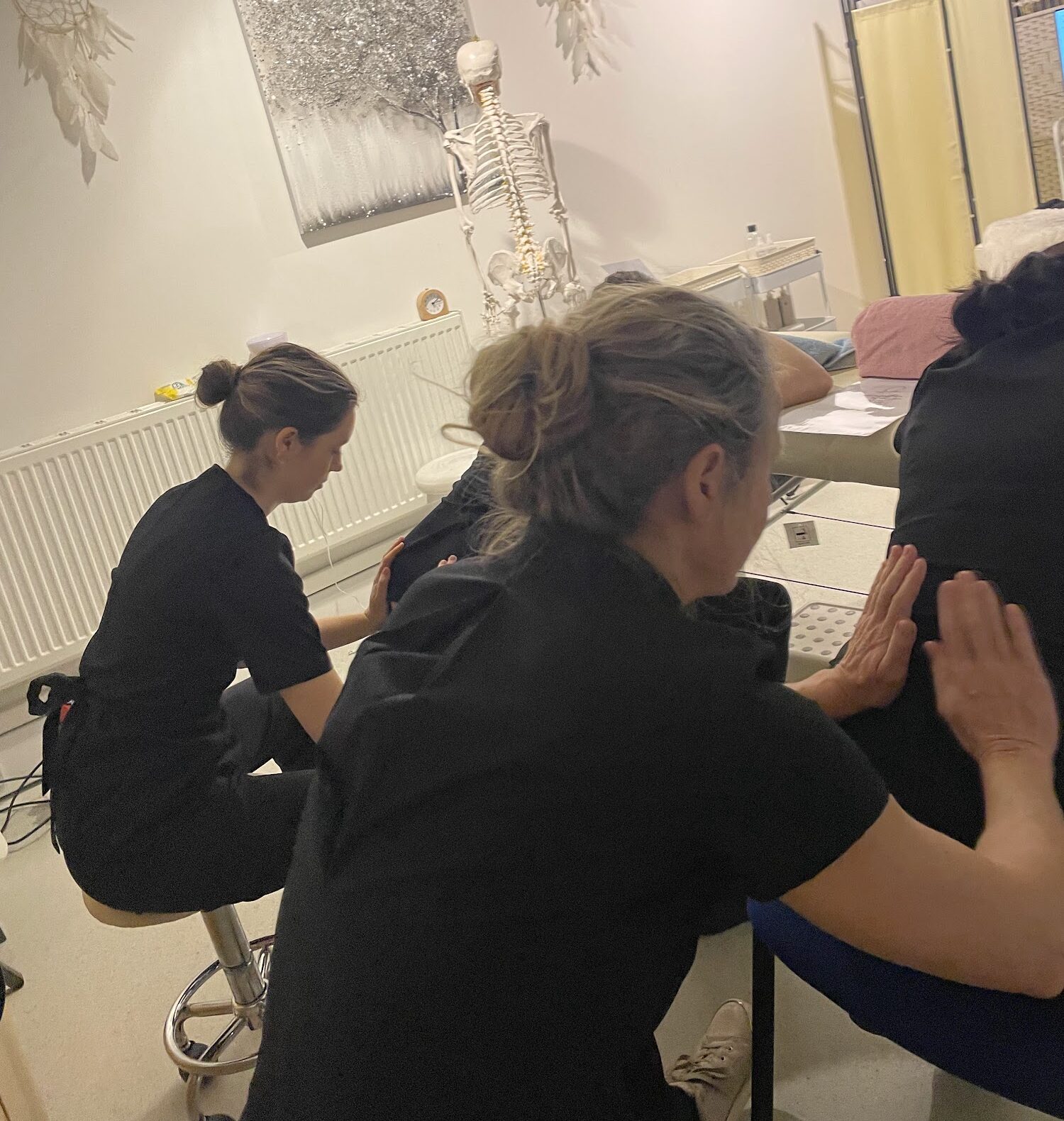Students practising Indian head massage on seated partners during a training day