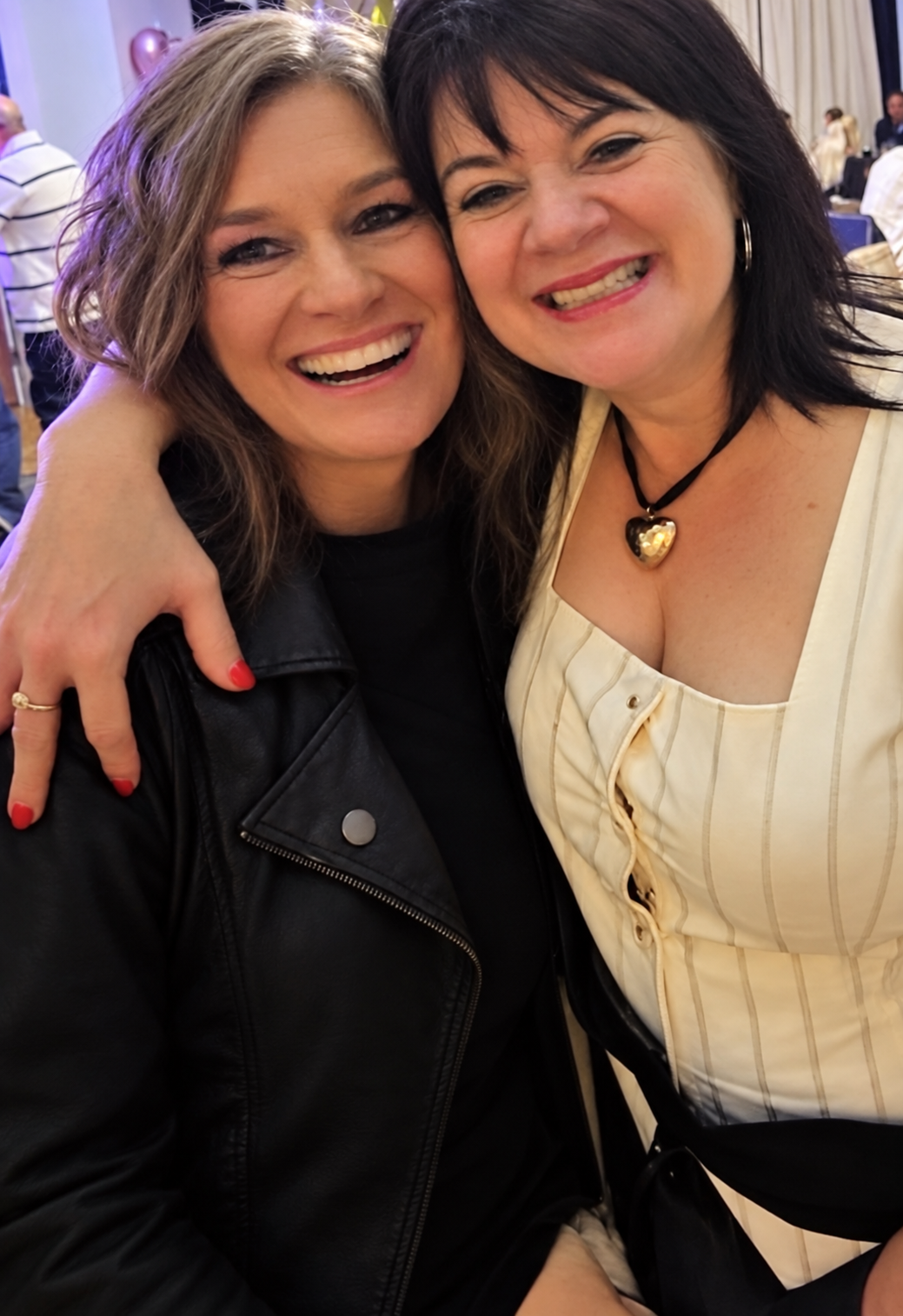 Two women smiling together at an event: the author and Jenn, her lash technician